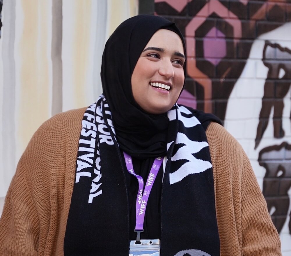 Nuha at WIFF. Smiling woman in hijab and festival scarf. Windsor International Film Festival.